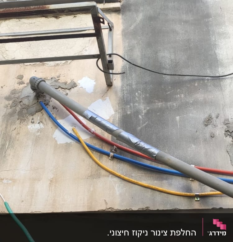 צינורות צבעוניים מחוברים לקיר חיצוני של בניין